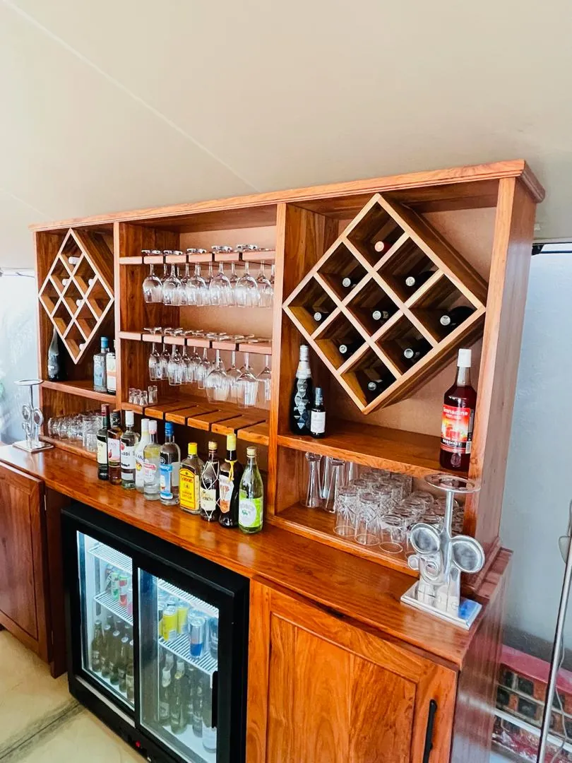 Wooden bar unit with wine racks, glass shelves and an under-counter fridge