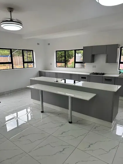 Modern kitchen with grey cabinets and a white island with a breakfast bar